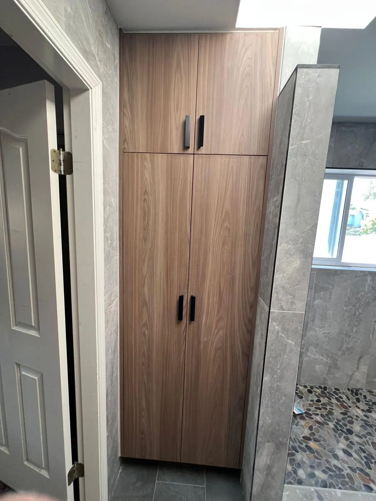 Tall custom bathroom storage cabinet beside shower in Kerrisdale Vancouver